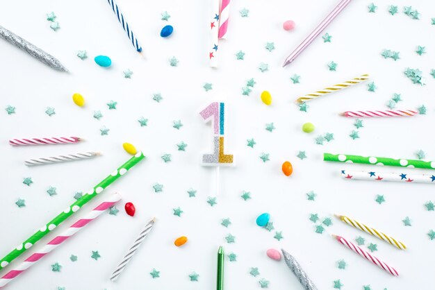 A top view candles and candies birthday decorations on white desk, birthday party celebration