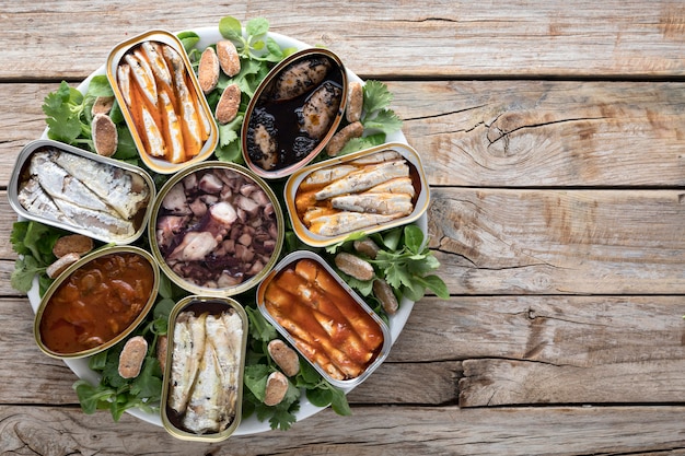 Free photo top view of cans of seafood on plate with copy space