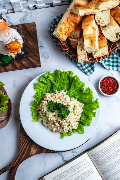 Top view capital salad on lettuce with bread and a slice of lemon on the table