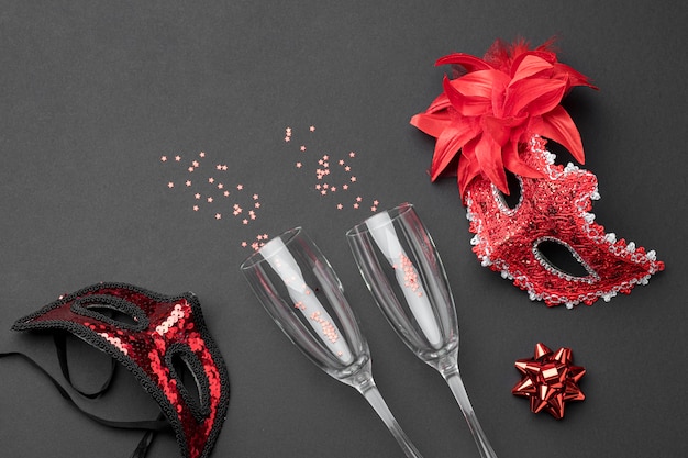 Top view of champagne glasses and carnival masks with feathers