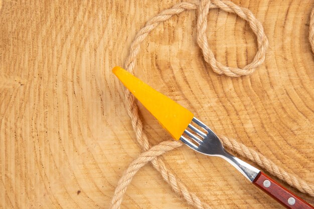 Top view cheese on fork rope on wooden table