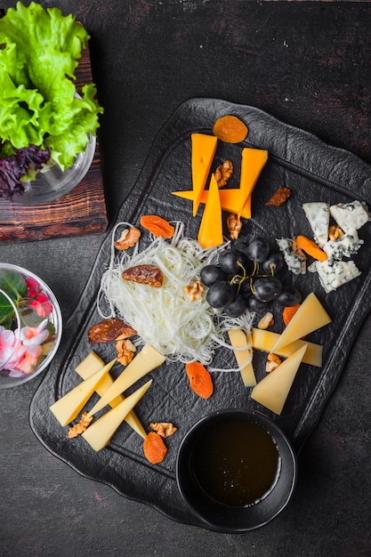 Free Photo top view cheese platter with grapes and nuts and honey in tray