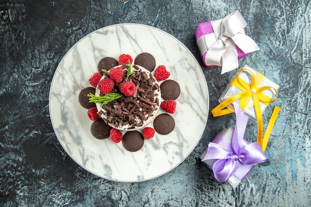 Top view cheesecake with chocolate on oval plate xmas gifts on grey surface