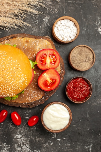 Free photo top view cheesy meat burger with seasonings on dark floor bun sandwich fast-food