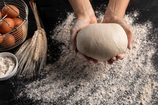 Top view of chef holding bread dough