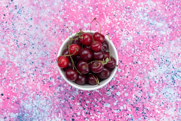 Top view cherries inside cup on the colored desk fruit fresh color mellow sour