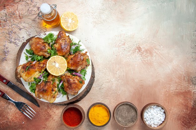 Free Photo top view chicken fork knife chicken with onion herbs spices in bowls bottle of oil lemon