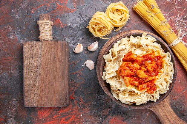 Free photo top view chicken with dough pasta dish on dark floor dark pasta dish dough