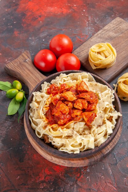 Top view chicken with dough pasta dish with tomatoes on dark desk pasta dough meal