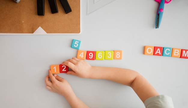 Top view of child at desk learning numbers and letters