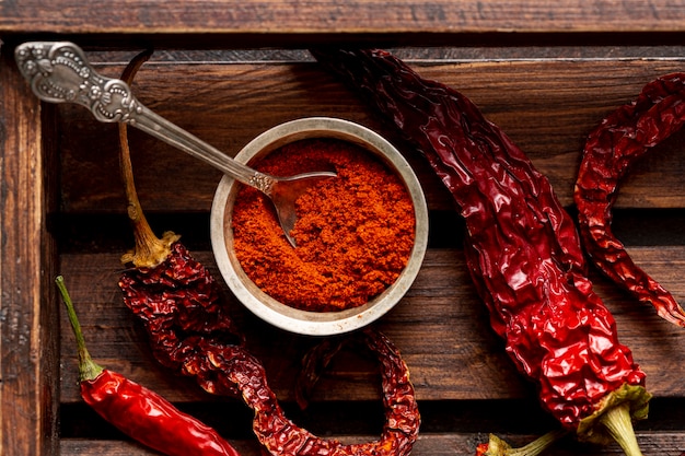 Top view of chili peppers on wooden tray with powder