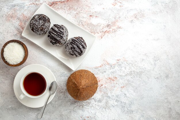 Top view chocolate cakes with cup of tea on white background chocolate cake biscuit sugar sweet cookies