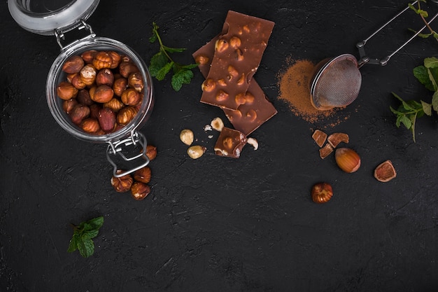 Top view chocolate and jar with hazelnuts