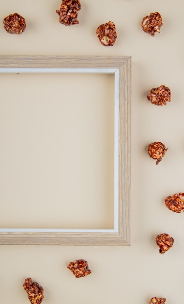 Free photo top view of chocolate popcorn with frame on white with copy space