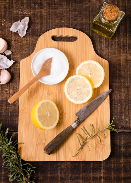 Top view of chopping board with lemon slices and knife