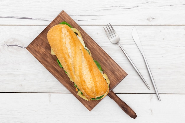 Top view of chopping board with sandwich on top