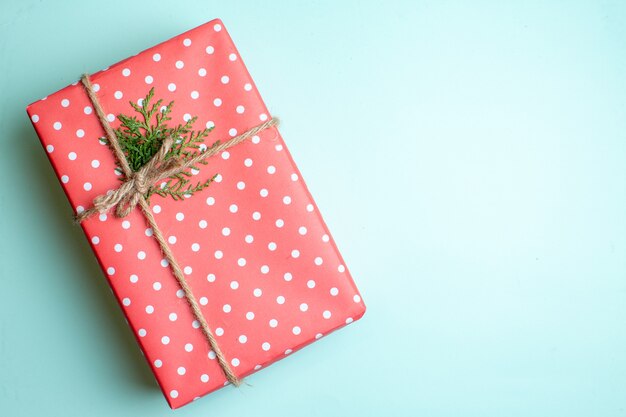 Top view of Christmas background with gift box on the right side on pastel green background