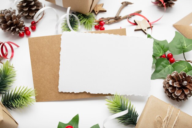 Top view of Christmas composition with gift box, ribbon, fir branches, cones, anise on white table