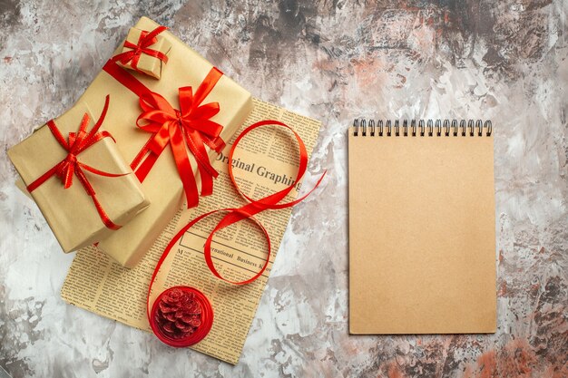 Top view christmas presents with red bows and notepad on white background