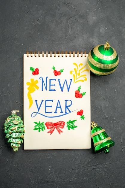 Free photo top view christmas tree toys with new year written notepad