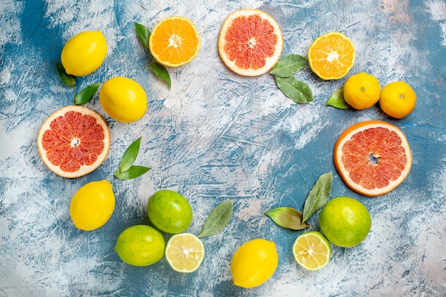 Top view circle row citrus fruits lemons grapefruits mandarins on blue white table