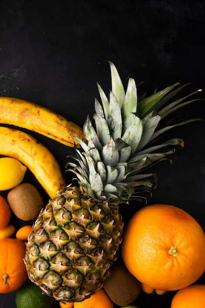 Free Photo top view of citrus fruits as orange pineapple banana and others on black surface