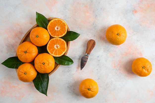 Free photo top view of clementine mandarins over wooden plate