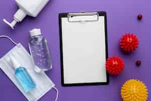 Free photo top view of clipboard with viruses and medical mask