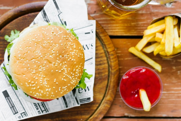 Top view close-up of burger and fries on wooden board