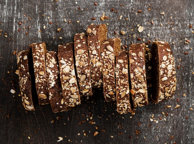 Top view close-up slices of whole-grain bread and wooden background