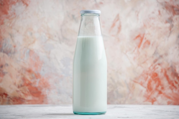 Free photo top view of closed glass bottle filled with milk on pastel colors surface