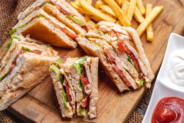 Top view club sandwich with french fries ketchup with mayonnaise