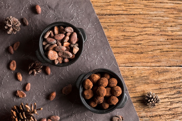 Top view cocoa beans and chocolate truffles in bowls