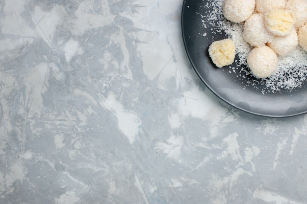 Free photo top view coconut candies inside plate on white