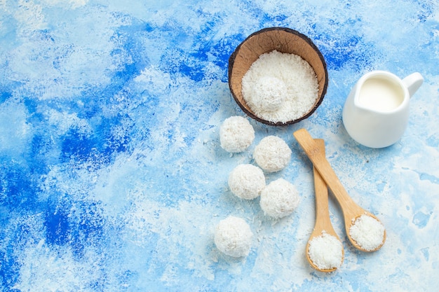 Free Photo top view coconut powder bowl coconut balls rope wooden spoons milk bowl on blue white background