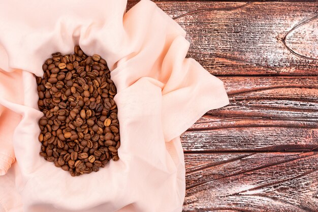 Top view coffee beans in cloth on wooden surface