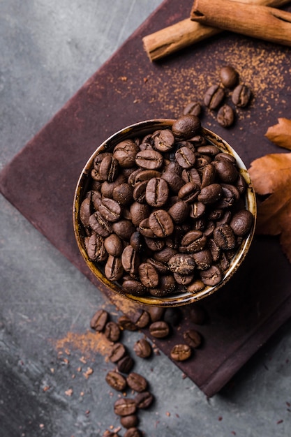 Top view coffee beans in cup on cutting board with cinnamon