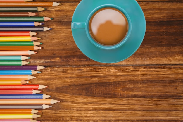 Free photo top view of coffee cup with colored pencils