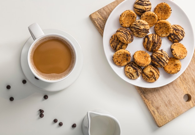 Top view of coffee cup with plate of cookies