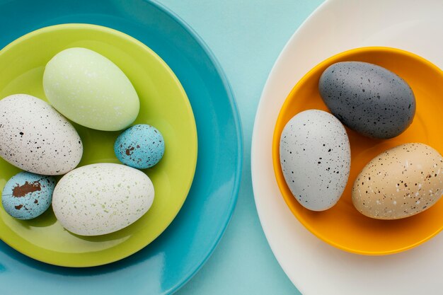 Top view of colored easter eggs on multiple plates