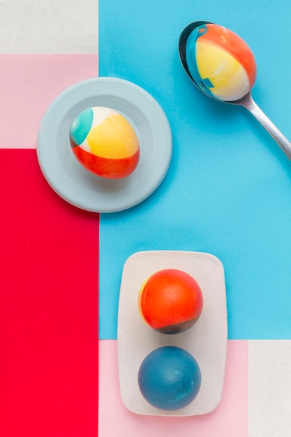 Free Photo top view of colored eggs on plate for easter with spoon