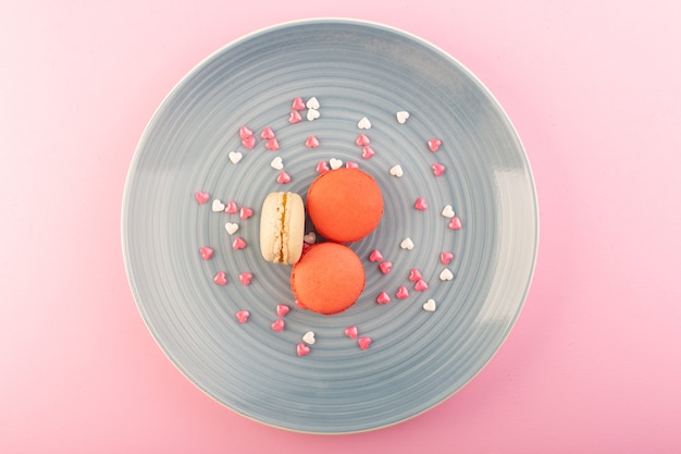 Free photo a top view colored french macarons inside blue plate