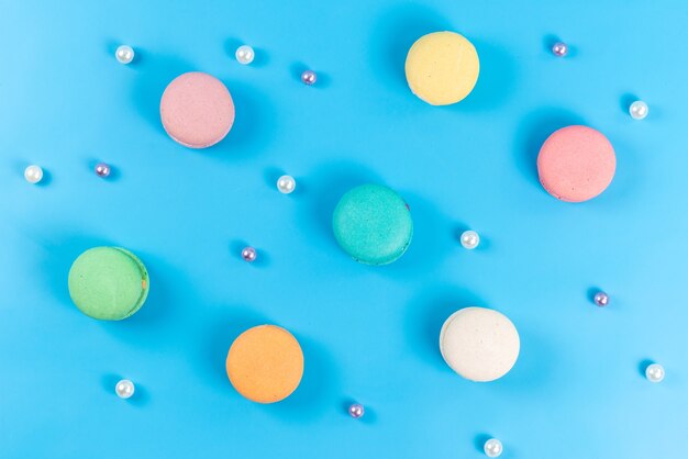 A top view colored french macarons round sweet delicious isolated on blue