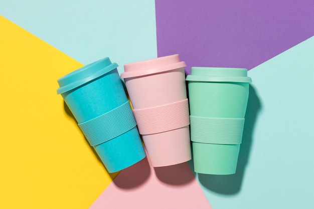 Free photo top view colored reusable cups on the table