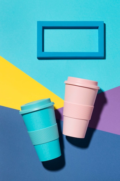 Free photo top view colored reusable cups on the table