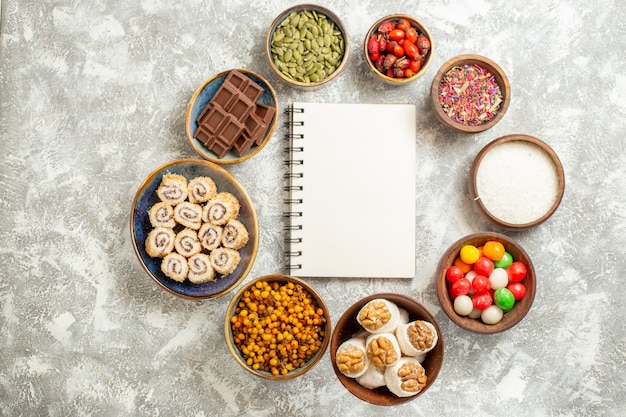 Top view colorful candies with sweet roll candies on a white table candy color sweet