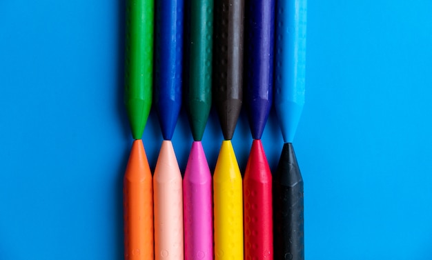 Top view colorful crayons lined up facing each other