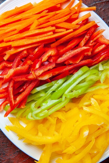 Top view colorful cut peppers on white plate