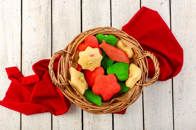 Free Photo a top view colorful delicious cookies different formed inside brown basket on the grey surface