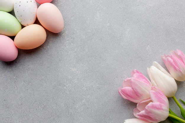 Free photo top view of colorful easter eggs and beautiful tulips